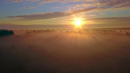 Wall Mural - aerial misty sunrise shot with for and beautiful sunlight on background