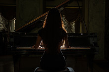 Young Charming Brunette Girl Playing The Piano
