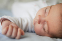 Newborn Baby Girl Sleeping On Blue Sheets