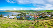Beautiful panorama view of Stanley's residential houses in town and coast line against blue sky on a bright sunny day. Elevated view from 'The Nut' - a volcanic plug in Stanley, Tasmania, Australia