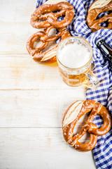 Wall Mural - Oktoberfest food menu, bavarian pretzels with beer bottle mug, white wooden background copy space top view