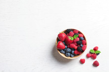 Bowl With Raspberries And Different Berries On Wooden Table, Top View