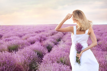 Young woman with bouquet in lavender field