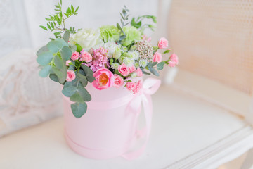 Wall Mural - Pink vase with beautiful roses stands on the white table