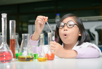 Wall Mural - little scientist in lab coat making experiment
