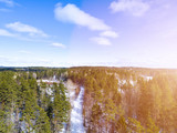 Fototapeta Na ścianę - Aerial view of a winter road. Winter landscape countryside. Aerial photography of snow forest. Captured from above with a drone. Aerial photography. Nature from a birds eye view. Qadcopter.