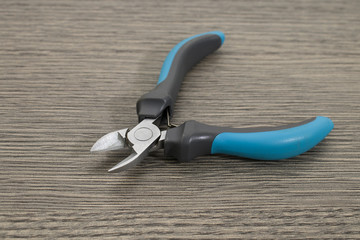 Detailed blue plier on a decorated wood table