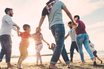 Family friends having fun on the beach at sunset