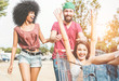 Young millennials people racing with shopping cart - Happy crazy friends having fun with trolleys in car park - Youth lifestyle, friendship, happiness, multiracial and party concept .