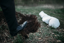 Male Murderer With A Shovel  Is Digging A Grave