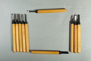 Set of wood carving knives on a gray background with empty space