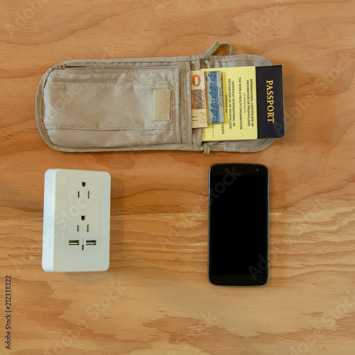 Fotografie, Obraz Travelling essentials carry-on a passport wallet with yellow card, smartphone an