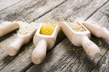 Wall Mural - raw cereal foods: millet, brown and white rice, flour, oatmeal grains on old wood background