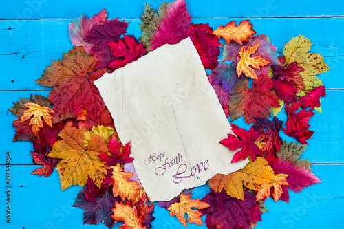 Fotografie, Obraz Hope, Faith, Love on parchment paper with colorful autumn leaves border on rusti