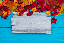 Blank Rustic Sign With Colorful Autumn Leaves Border Hanging On Antique Rustic Teal Blue Wood Background; Seasonal Background With Copy Space