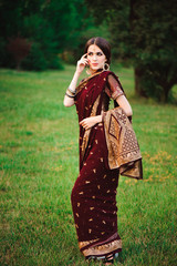 Beautiful Arabian woman portrait. Young Hindu woman with mehndi tattoos from black henna on her hands.