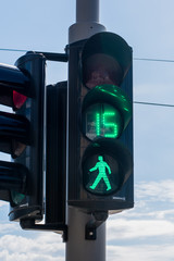 A traffic light pedestrian walking signal, with fifteen seconds left of a green light