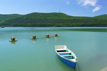 Bright Blue Rowing Boat On The Emerald Water Of The Mountain Lake Abrau-Durso