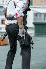 Wall Mural - man dressed in a bulletproof vest, a shirt in his blood, pursues a victim with a gun