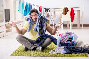 Wall Mural - Handsome man husband doing laundering at home