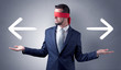© ra2 studio - Covered eye businessman choosing between two directions