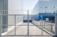 Metal Gates In An Industrial Area With Barbed Wire Protection