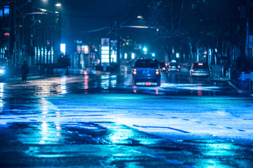 Wall Mural - Cars driving on wet road in the rain and colored lights reflected on the wet asphalt road