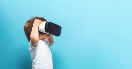 Wall Mural - Toddler boy with a virtual reality headset on a blue background