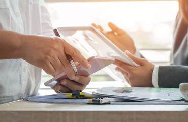 Co working team meeting concept:  Asian Business woman working and studying together with tablet document graph paper in office, discuss finance and marketing solution reporting file in working place