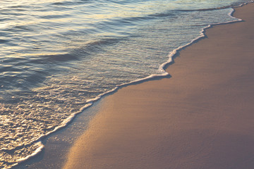 Wall Mural - Foam waves on the Caribbean ocean beach. Small foamy waves. Wallpaper with vintage effect applied.