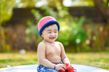 Wall Mural - Cute indian baby boy playing at garden