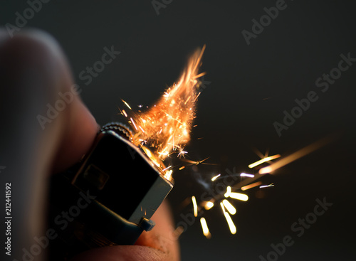 Fotomural Lighters with flame sparking on dark background