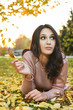 © dobok - young woman lying down on the ground in a park in autumn