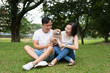 © Kenishirotie - Lovely asian couple with their pet shih tzu puppy at outdoor park