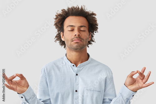 Curly Male With Dark Skin And Curly Hair Dressed In Shirt Keeps