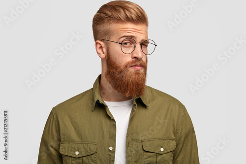 Sideways Shot Of Handsome Bearded Ginger Male Looks With