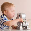 © goodmoments - Portrait of little toddler boy playing with electronic dog.