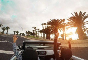 Happy couple having fun in convertible car in summer vacation