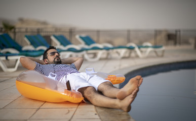 middle aged arab man by a pool