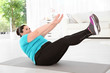 © New Africa - Overweight woman doing exercise on mat at home