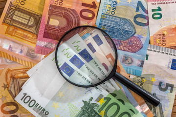 Top view of magnifying glass on euro banknote background