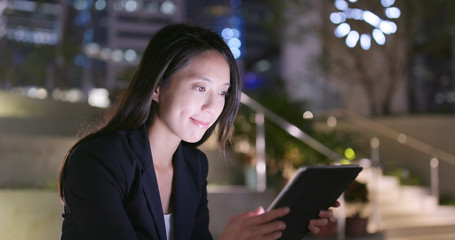 Wall Mural - Young businesswoman use of tablet computer at night