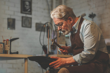 Wall Mural - An elderly man in a workshop