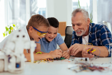 Wall Mural - practical class. nice smart boy sitting together with their teacher while having a science lesson
