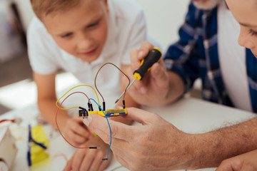 Wall Mural - digital development. electronic microscheme with wires being in hands of a nice positive man