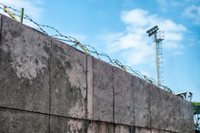 Wall Stone With Coils Barbed Wire And Security Camera