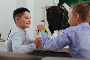 Wall Mural - new technologies. nice smart boys discussing robots while sitting at the school desk