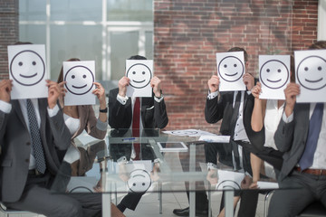 business team keeps smiley icons sitting at the Desk