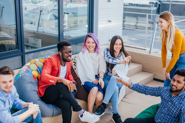 Wall Mural - Non-formal business meeting of young talanted top photographers. Top view of buiness team brainstorming while sitting at the office lounge zone