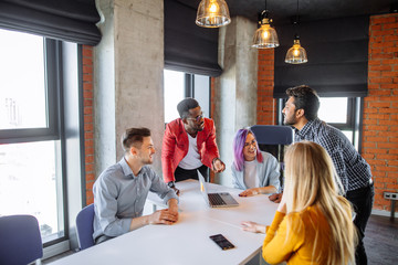 Multiracial creative young designers having a business discussion at modern office meeting room. Corporate Concept.